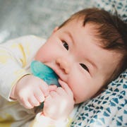 baby chewing on blue teether