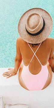 woman in swimsuit and hat by pool